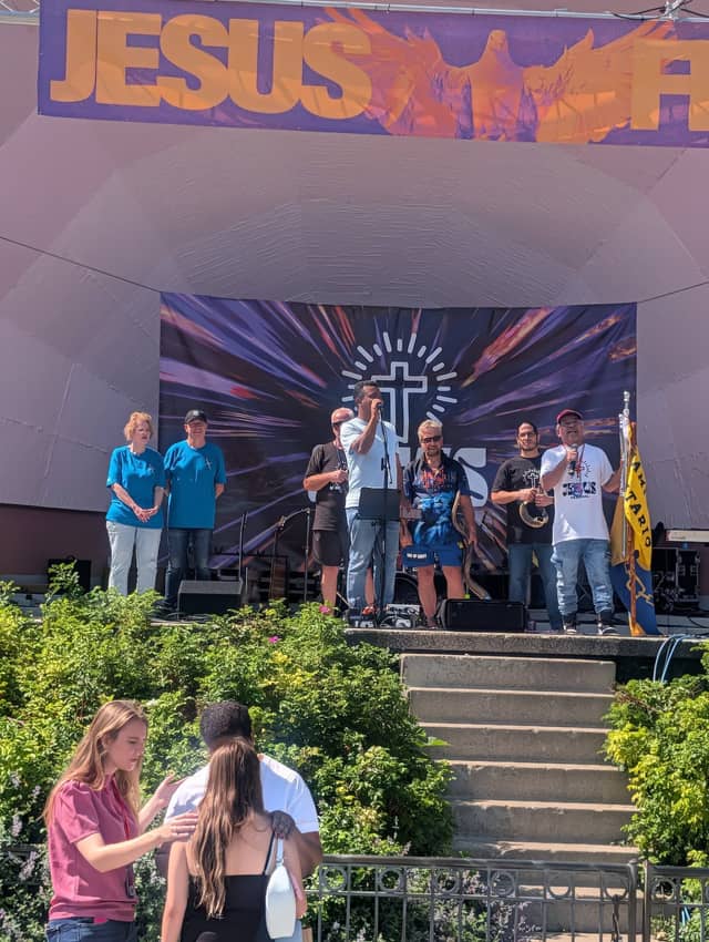 Pastors and leaders on the bandshell stage as prayer happens below, Jesus Festival Hamilton 2026