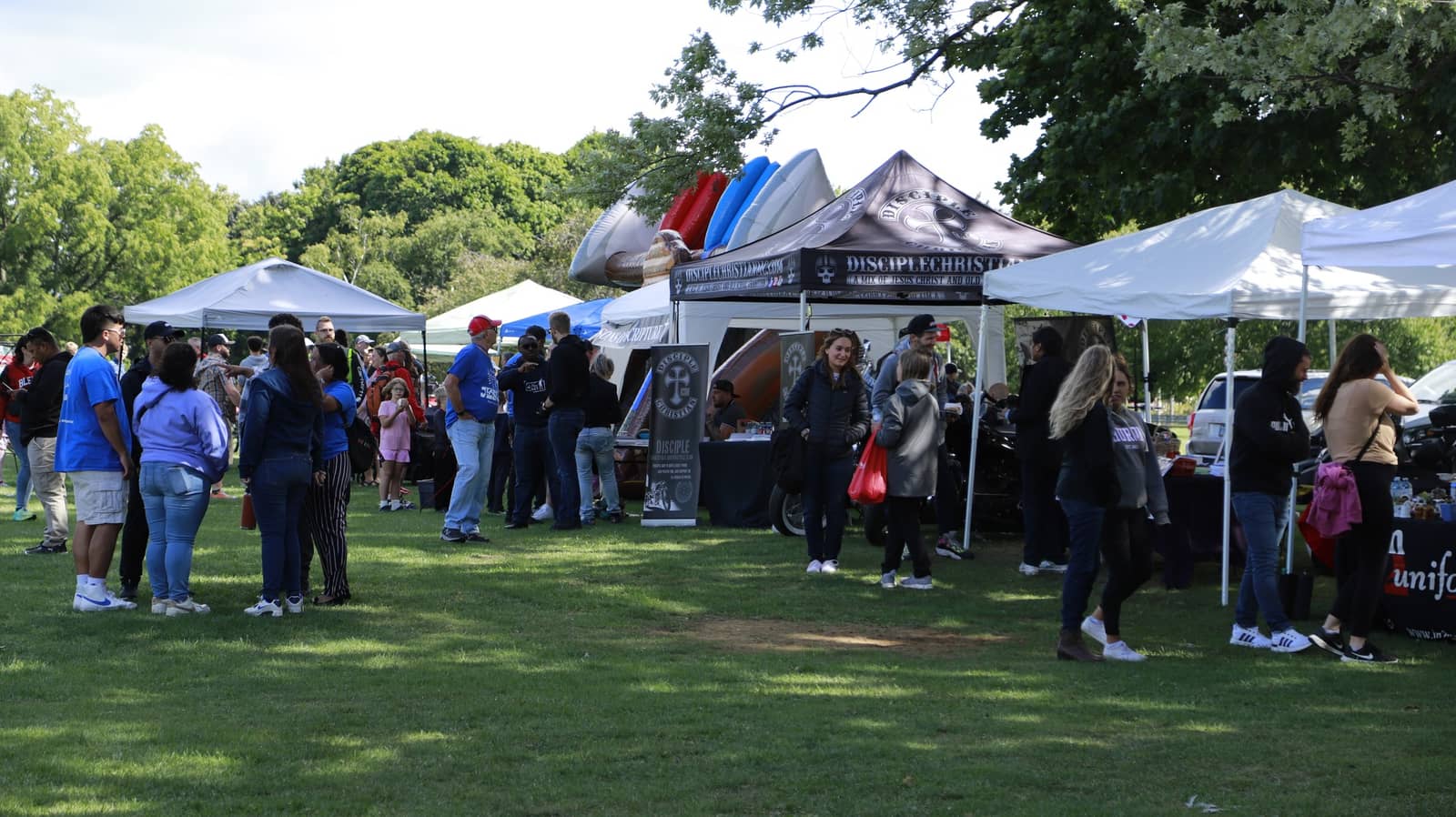 Visitors among the ministry and vendor tents on the lawn at Jesus Festival in Gage Park